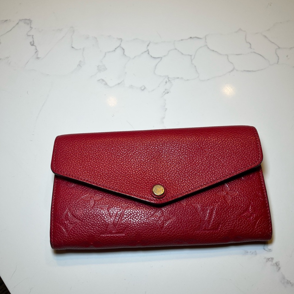 Red Louis Vuitton wallet with gold accents